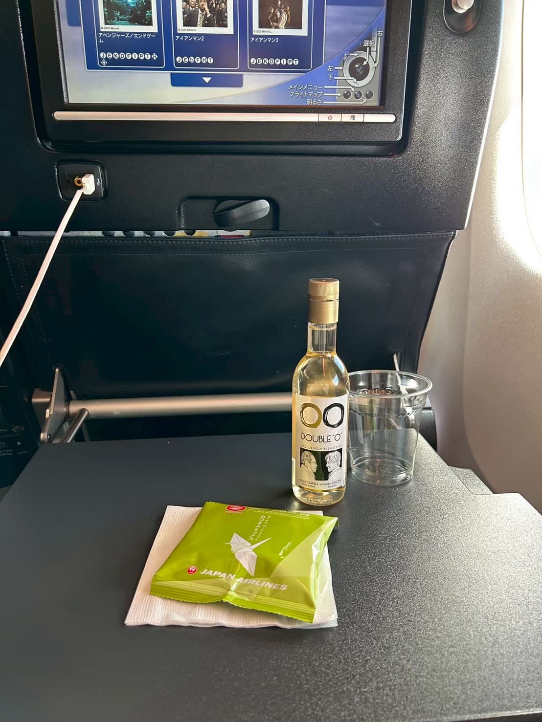 機内のトレイテーブル。ワインとJALのスナック